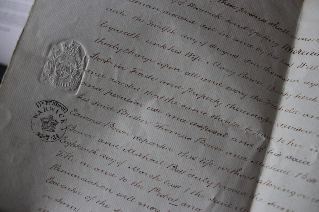 Mano escribiendo con bolígrafo sobre un documento en papel