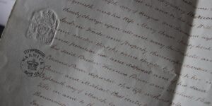 Mano escribiendo con bolígrafo sobre un documento en papel
