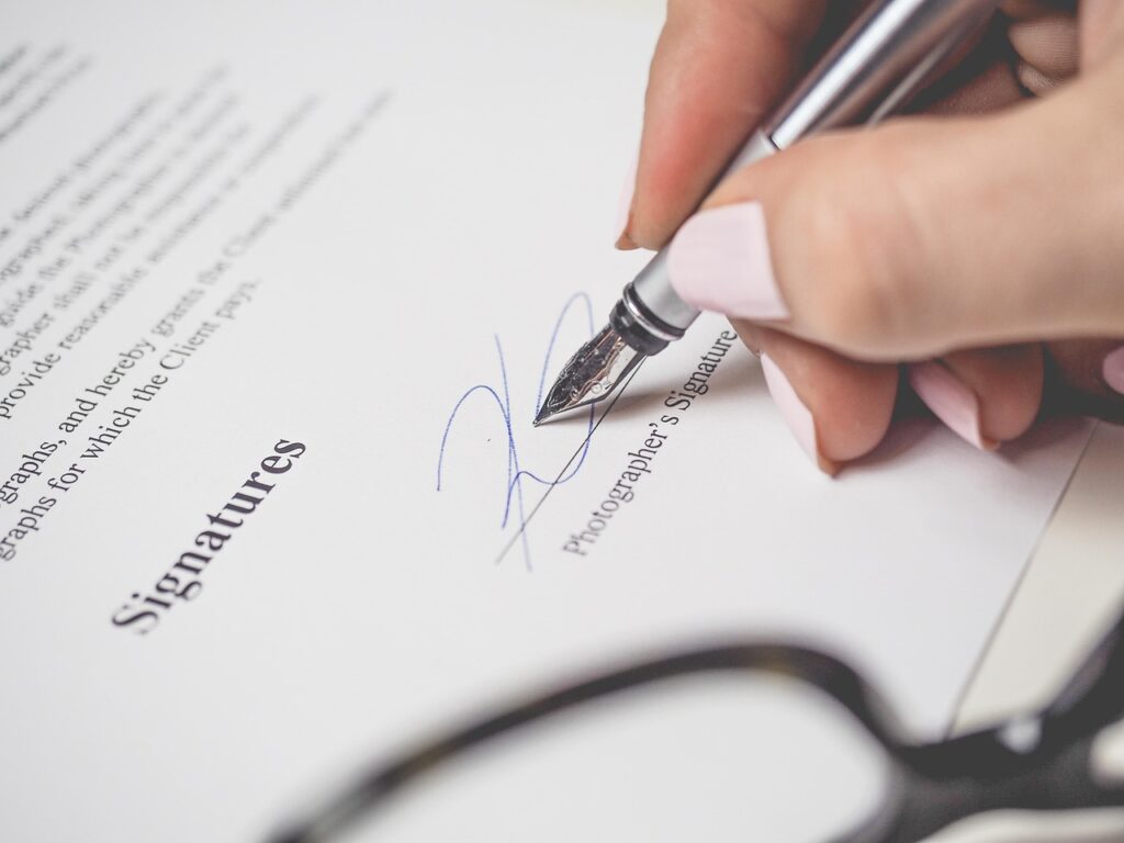 Persona firmando un contrato de trabajo con bolígrafo