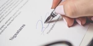 Persona firmando un contrato de trabajo con bolígrafo