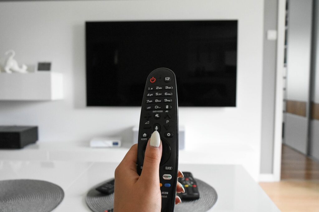 Televisor encendido en una sala de estar junto a un control remoto