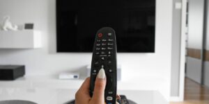 Televisor encendido en una sala de estar junto a un control remoto