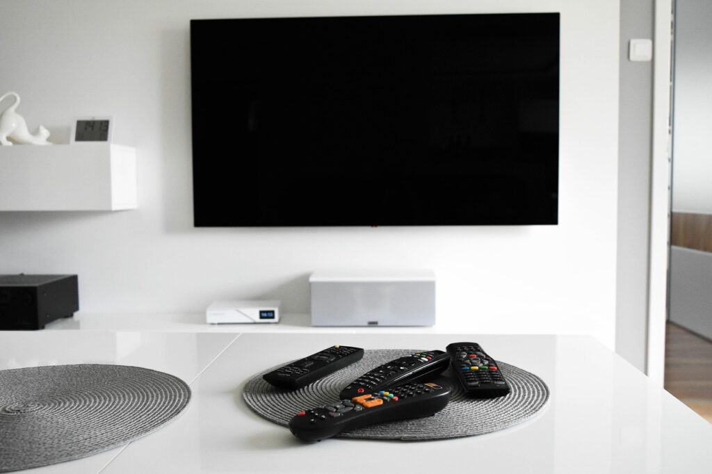Televisor encendido en una sala de estar con control remoto