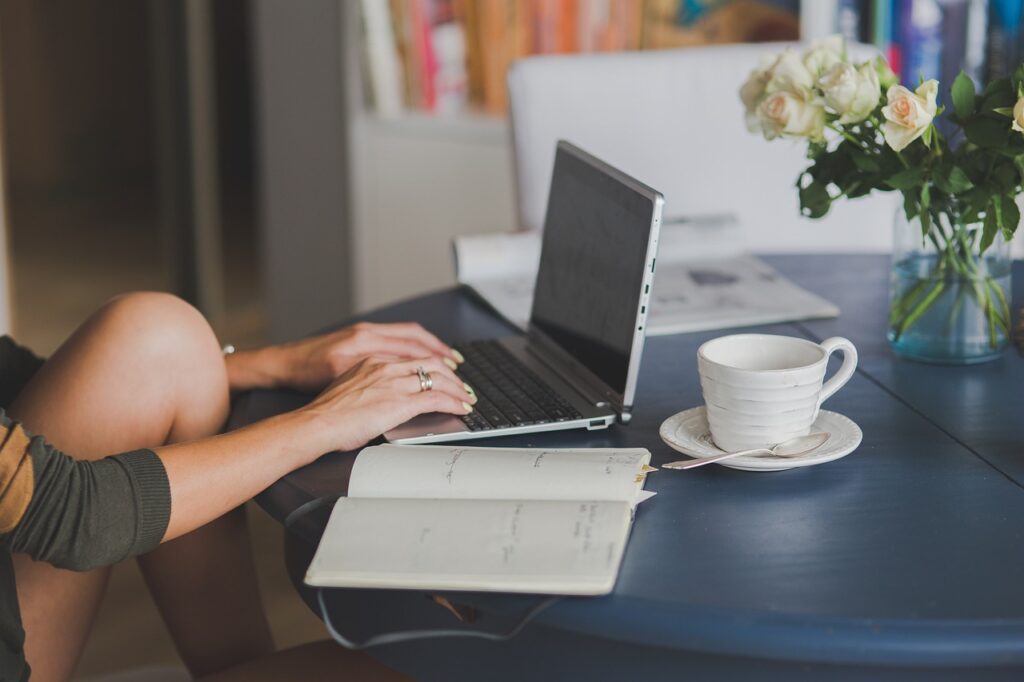 Computadora portátil y libreta sobre un escritorio de trabajo para un blog