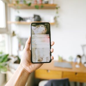 Mano sosteniendo un iPhone con notificaciones en la pantalla