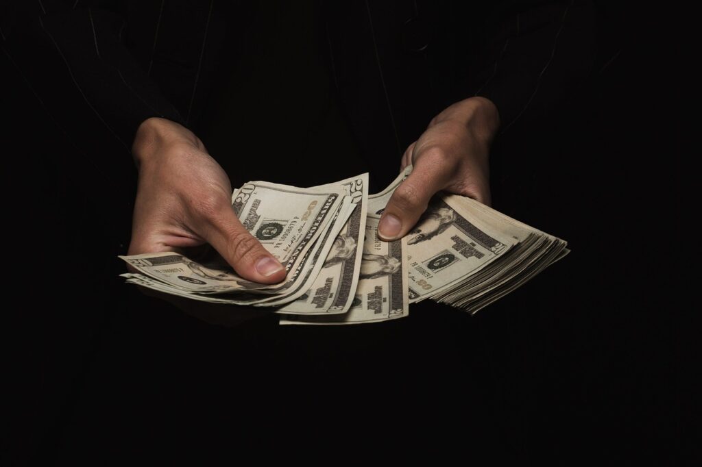 Manos contando billetes de dólar estadounidense