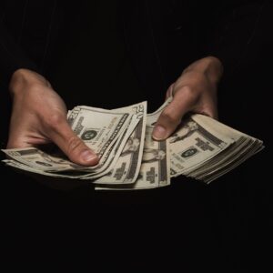 Manos contando billetes de dólar estadounidense