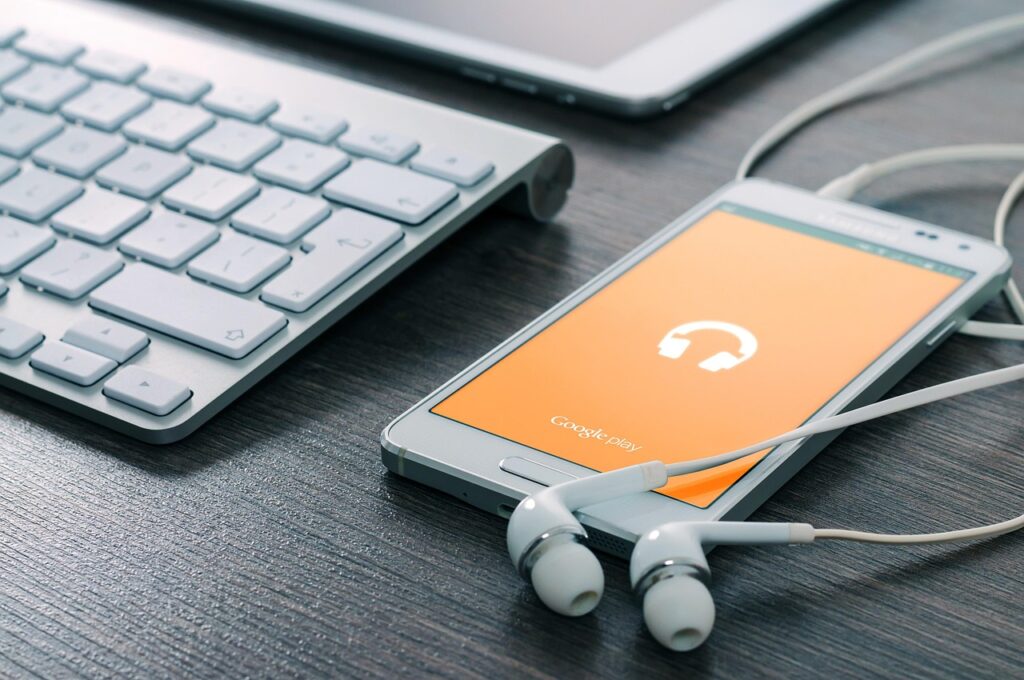Teléfono reproduciendo música junto a unos auriculares