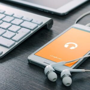 Teléfono reproduciendo música junto a unos auriculares