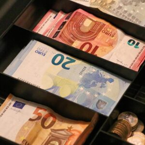 Caja con billetes y monedas que representa transferencias de dinero