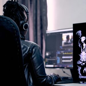 Persona con audífonos editando audio y video en una computadora